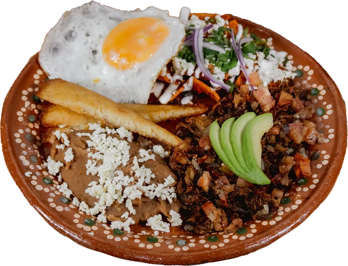 Borreguito hambriento: machaca de borrego, huevo estrellado, chilaquiles, tamal, frijoles con queso y aguacate en plato de barro